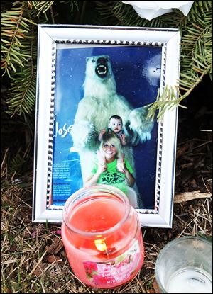 A photo of Kaitlin Gerber, with her nephew Nico Gerber, taken at the Toledo Zoo sits among items that have become part of a makeshift memorial at the Southland Shopping Center.  