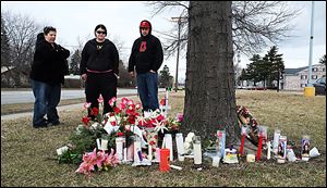 Chris Murray, from left, Sarah Sutphin, and Russell Castillo, pause at a makeshift memorial for Kaitlin Gerber, at the Southland shopping center at Glendale Avenue and Byrne Road on Tuesday, March 26, 2013.  They are friends of Ms. Gerber, who was shot to death at the site by former boyfriend Jashua Perz on Sunday.