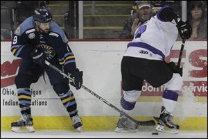 Toledo's Aaron Bogosian (9) pulls the puck away from Reading's Nikita Kashirsky earlier this month.