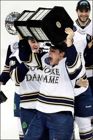 Notre Dame's Anders Lee lifts the CCHA hockey championship trophy in this file photo.