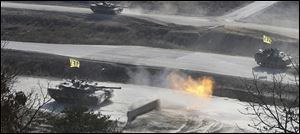 A South Korean K1 army tank fires live rounds during an exercise at Seungjin Fire Training Field in mountainous Pocheon, South Korea, near the border with North Korea, Wednesday, March 27, 2013. 