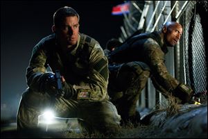 Channing Tatum, left, as Duke and Dwayne Johnson as Roadblock in a scene from the film, 