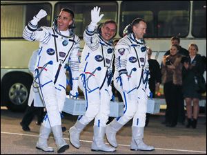 Russian Cosmonauts Alexander Misurkin, right, Pavel Vinogradov, center, and U.S. astronaut Christopher Cassidy, crew members of the mission to the International Space Station, ISS, walk prior launch.