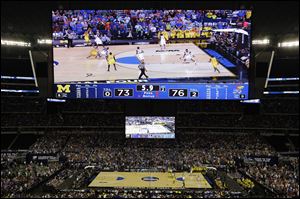Michigan's Trey Burke makes a three-point basket in the final seconds of the second half to tie the game against Kansas tonight in Arlington, Texas.