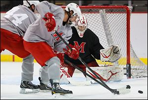 Miami goalie Anthony Jacaruso defends against teamate Sean Kuraly during practice at Huntington Center on Friday. The RedHawks play the second game of the Midwest regional today.