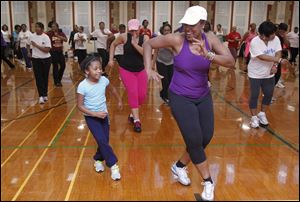 Heather Hayward, 9, works out with instructor Angela Steward during Fabulously Fit at Scott High long after the last bell had rung on a Monday evening.