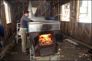 Johanna Lake checks the evaporator at David Moore's Crooked Chimney sugarhouse  Lee, N.H. Moore, New Hampshire's only known commercial birch syrup producer, got his start in 2008, when he was a student at the University of New Hampshire.