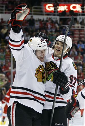 Chicago Blackhawks left wing Brandon Saad, left, celebrates his first period goal with Chicago Blackhawks right wing Michael Frolik (67), of the Czech Republic, during an NHL hockey game against the Detroit Red Wings Sunday, March 31, 2013, in Detroit. (AP Photo/Duane Burleson)