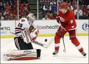 Chicago Blackhawks goalie Corey Crawford (50) makes a save on a shot by Detroit Red Wings left wing Justin Abdelkader (8) in the second period of an NHL hockey game Sunday, March 31, 2013, in Detroit. (AP Photo/Duane Burleson)