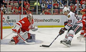 The Blackhawks' Brandon Saad drives onto Red Wings goalie Jimmy Howard for one of his two goals in Chicago's 7-1 rout.