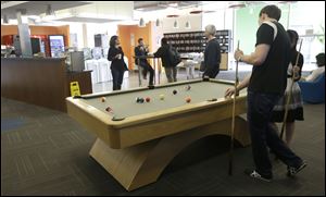 Google employees shoot pool at in a break room at the Google campus in Mountain View, Calif.