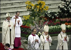 Pope Francis, holding the pastoral staff, celebrates the Easter mass in St. Peter's Square at the Vatican.