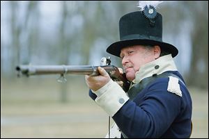 Ralph Naveaux wears the uniform of  Lacroix’s Company of Michigan Volunteers during a re-enactment at River Raisin National Battlefield Park in Monroe  on Thursday.