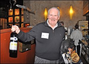 Don Harbaugh shows the bottle of wine he purchased at the St. Francis de Sales' Knight of the Vine benefit.