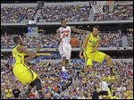  Michigan's Trey Burke (3) passes the ball to Tim Hardaway, Jr., in front of Florida's Casey Prather for an easy dunk in the second half. The Wolverines  (30-7) will play Syracuse (30-9) in the Final Four on Saturday night in Atlanta.