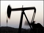  In this Tuesday, Nov. 27, 2012, photo, an oil pump works at sunset in the desert oil fields of Sakhir, Bahrain. Oil prices are lower as traders remain unsure whether positive U.S. economic news signals an increase in demand for fuel. The lower oil prices Tuesday matched a slight decline in U.S. stocks markets.  (AP Photo/Hasan Jamali)
