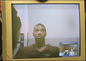 Jonathon Johnson, 23, is arraigned via a video appearance today in Toledo Municipal Court on a charge of aggravated murder.