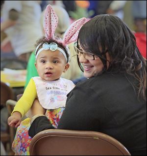 Kelsea Hueston of Toledo holds her daughter Maurissa Robin-son at the dinner, which featured traditional Easter fare. 