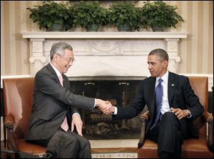 President Barack Obama shakes hands with with Singapore Prime Minister Lee Hsien Loong during their meeting in the Oval Office of the White House in Washington.