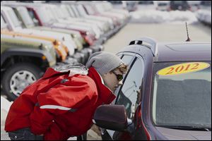 Matthew Miller shops for a car at an Omaha dealership. Automakers including Ford, Chrysler, GM, Toyota, and Nissan all reported sales increases in March, with pickup trucks leading the way.