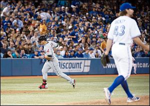 Cleveland shortstop Asdrubal Cabrera rounds the bases past Toronto Blue Jays R.A. Dickey after hitting a two-run home run during the fifth inning Tuesday in Toronto.