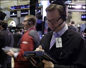 Trader Michael Bercovici, right, works on the floor of the New York Stock Exchange today. Stocks are notching small gains in early trading after the U.S. government reported that the number of people applying for unemployment benefits rose to the highest level since late November.