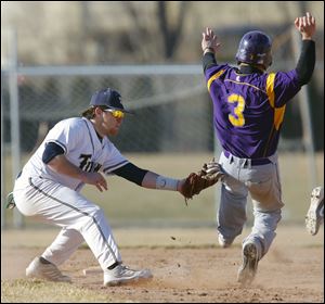 St. John's Jim Scott tags out Maumee's Tommy Henry at second base during the fifth inning. Maumee grabbed a 3-0 lead before the Titans stormed back for an 8-7 non-league victory.