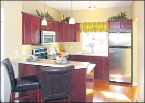 Cherry cabinets with crown molding and stainless steel appliances are very stylish.