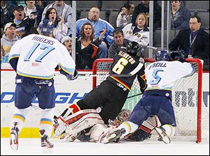 Walleye goalie Kent Simpson is knocked into his goal by Cincinnati's Taylor Ellington (6) and teammate Wes O'Neill.
