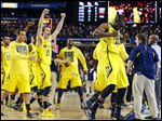  Michigan players including Tim Hardaway Jr., right, and Nik Stauskas (11) celebrate after defeating Syracuse on Saturday in Atlanta.