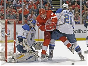 The Blues’ Patrik Berglund (21) defends against the Red Wings’ Justin Abdelkader (8) in front of goalie Brian Elliott (1) in the second period on Sunday. Berglund had an assist in the lone goal in the game while Elliott made 28 saves for the shutout.