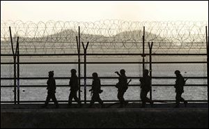 South Korean army soldiers patrol along a barbed-wire fence at sunset near the border village of Panmunjom, which has separated the two Koreas since the Korean War, in Paju, north of Seoul, South Korea.