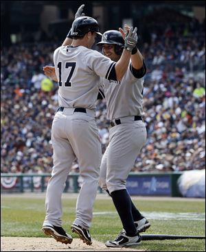 New York Yankees' Jayson Nix (17) is congratulated by teammate Francisco Cervelli after they both scored on Nix's two-run home run during the second inning of a baseball game against the Tigers in Detroit.
