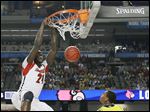  Louisville forward Montrezl Harrell dunks against Michigan forward Glenn Robinson III in the first half of the NCAA championship game in Atlanta. It is the third title won by Louisville. The Wolverines finish 31-8.