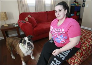 Joleen Gambardella rewards Missy with a tofu treat after giving the English bulldog her medication to ease the dog’s arthritis pain.