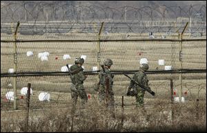 South Korean army soldiers patrol along a barbed-wire fence near the border village of Panmunjom in Paju, South Korea, today.