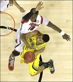 Michigan guard Trey Burke goes to the basket as Louisville center Gorgui Dieng defends in the NCAA championship game. Burke finished with 24 points.