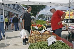 Toledo chef Tony House, left, talks with Andy Keil at his stall for Andy Keil Greenhouse as Mr. House shops at the Perrysburg Farmers Market in August, 2010. 