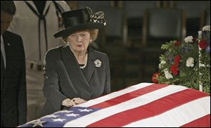 Former British Prime Minister Margaret Thatcher pauses at the casket of former U.S. President Ronald Reagan as he lies in state in the Capitol Rotunda on June 9, 2004.