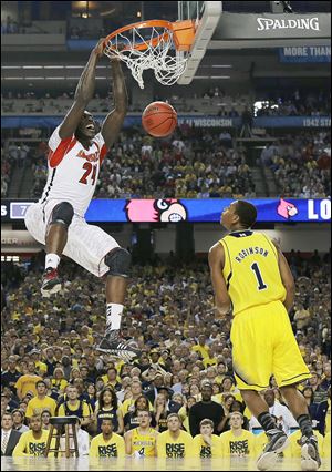 Louisville forward Montrezl Harrell dunks against Michigan forward Glenn Robinson III in the first half of the NCAA championship game in Atlanta. It is the third title won by Louisville. The Wolverines finish 31-8.