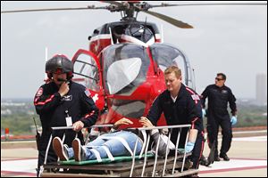 Life Flight personnel rush a victim today wounded in a stabbing attack on the Lone Star community college system's Cypress, Texas campus into Memorial Hermann Hospital in Houston. 