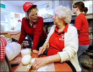 Cindy Leffler, left, talks with her  mother, Maxine Haas, as she chops onions at Pee Wee’s Dari Snak in Stony Ridge. Ms Haas’ father started the family business, which is marking its 50th anniversary.