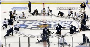 Quinnipiac players stretch at center ice during NCAA college hockey practice Wednesday at the Consol Energy Center in Pittsburgh. Quinnipiac is scheduled to play St. Cloud State today in a semifinal at the Frozen Four.