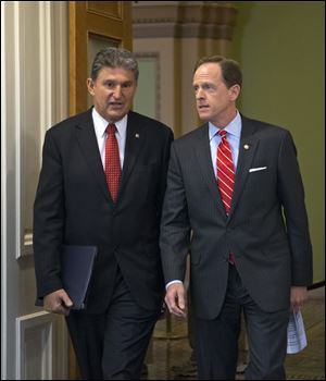 Sen. Joe Manchin of West Virginia, (D., W.Va.), left, and Sen. Patrick Toomey, (R., Pa.), arrive at a news conference on Capitol Hill in Washington, today, to announce that they have reached a bipartisan deal on expanding background checks to more gun buyers.