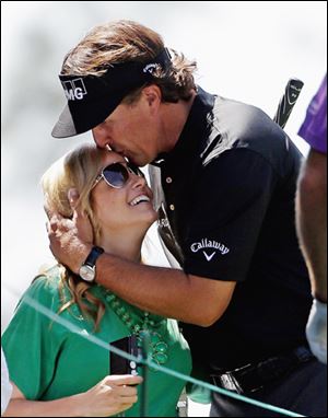 Phil Mickelson kisses his wife Amy on Wednesday during the par-3 tournament.