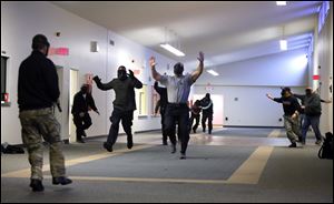 During an active shooter training scenario, an officer, left, arrives at the scene of a shooting as others portraying victims flee the area at the former Veterans Affairs Building, 3303 Glendale, today.