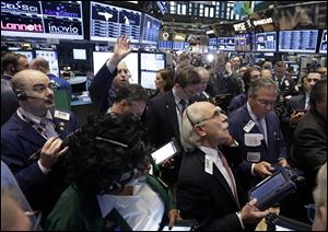Traders gather at a post on the floor of the New York Stock Exchange today. Stock indexes are little changed in early trading on Wall Street after three days of gains.