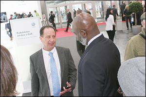 Paul Zito, vice president for international development for the Regional Growth Partnership, talks strategy with Mayor Mike Bell near the Volkswagen display. 