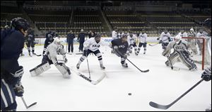 Yale players work on a drill between goaltenders Jeff Malcolm, left, and Nick Maricic, right, during NCAA college hockey practice Friday at the Frozen Four in Pittsburgh. Yale takes on Quinnipiac on the championship game today.
