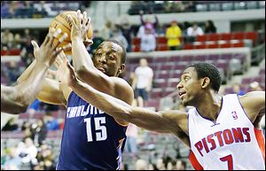 The Pistons’ Brandon Knight (7) reaches in on the Bobcats’ Kemba Walker (15) during the first half of Friday’s game at The Palace of Auburn Hills.